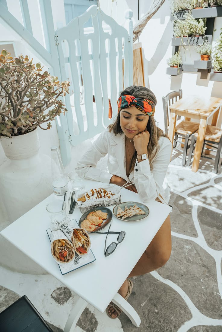 This may contain: a woman sitting at a table with food on it